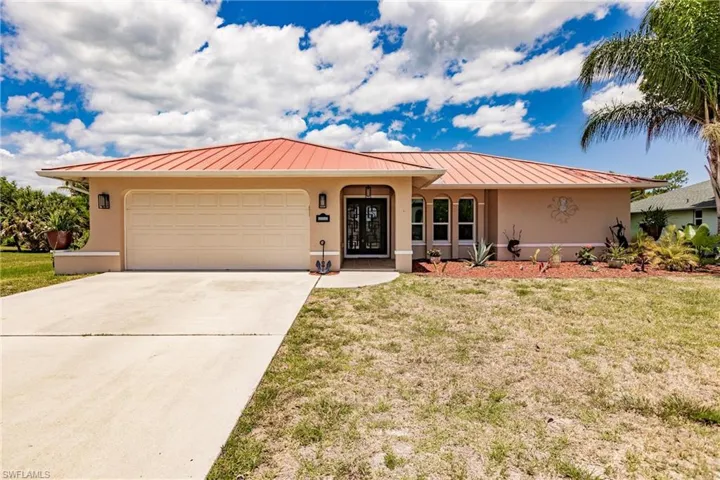 View of front of house featuring a front yard and a garage