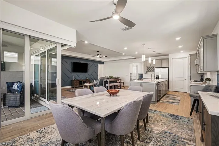 Dining room with ceiling fan, wood finish floors, recessed lighting, and a raised ceiling