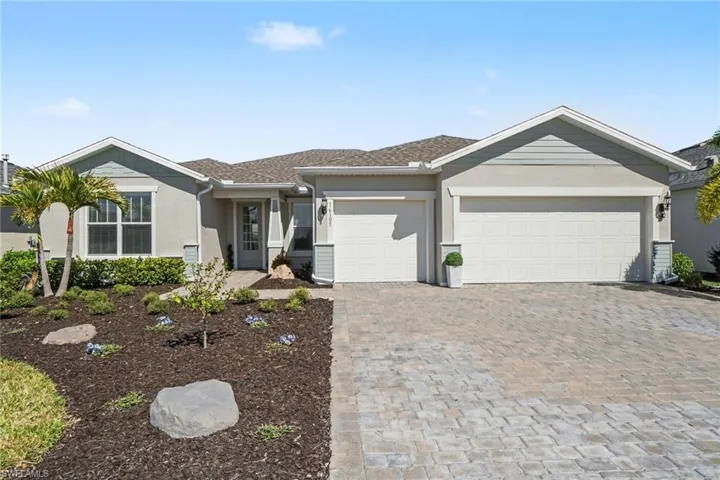 Single story home featuring decorative driveway, a garage, and stucco siding
