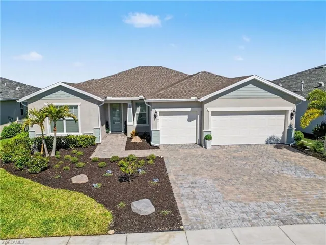 Single story home featuring a garage, decorative driveway, stucco siding, and roof with shingles