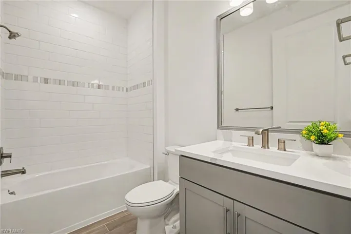 Bathroom featuring vanity, wood tiled floors, and shower / tub combination