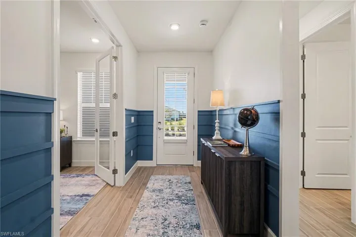 Foyer featuring wood tiled floors, a wainscoted wall, and recessed lighting