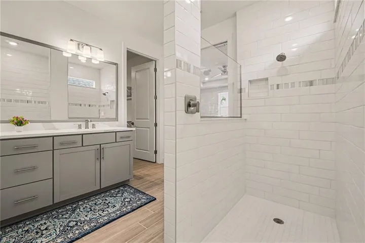 Full bathroom with vanity, a tile shower, and wood tiled floors
