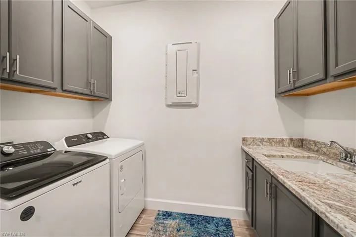 Laundry area featuring cabinet space, independent washer and dryer, and wood finish floors
