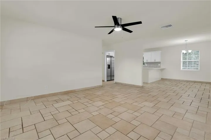 This Oversized Tiled Living Room Comes With Plenty Of Windows For More Natural Light And A Brand New Ceiling Fan/Light!