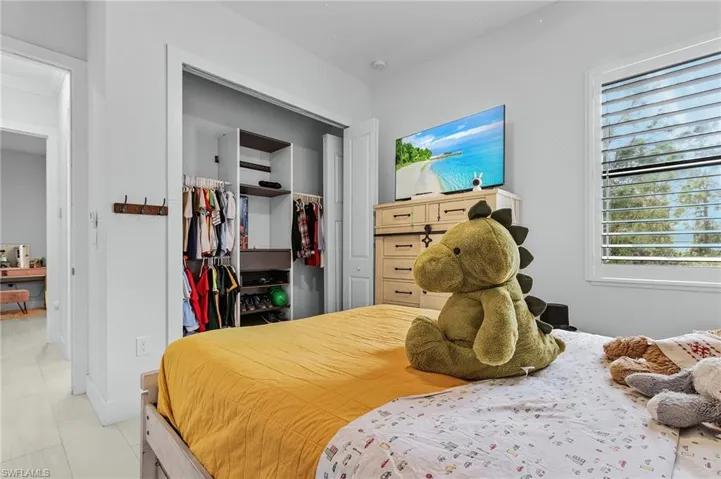 Bedroom with tile patterned flooring, a spacious closet, and a closet