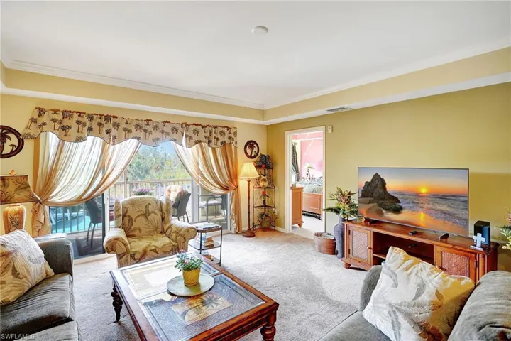 Carpeted living room with ornamental molding and visible vents