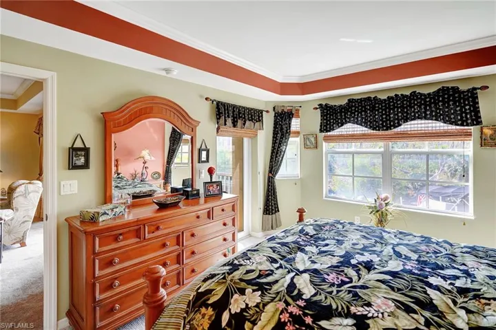 Carpeted bedroom featuring crown molding
