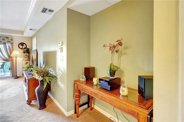 Hall featuring carpet, visible vents, and baseboards