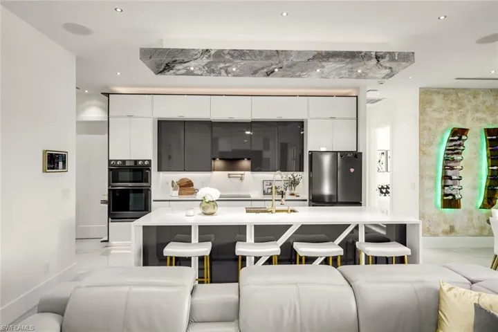 Kitchen featuring white cabinetry, modern cabinets, freestanding refrigerator, and a breakfast bar
