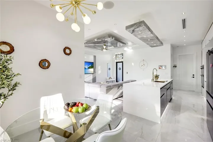 Dining area with visible vents, marble finish floor, and a chandelier