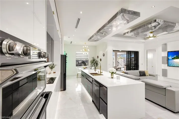 Kitchen with a sink, marble finish floor, white cabinetry, modern cabinets, and open floor plan