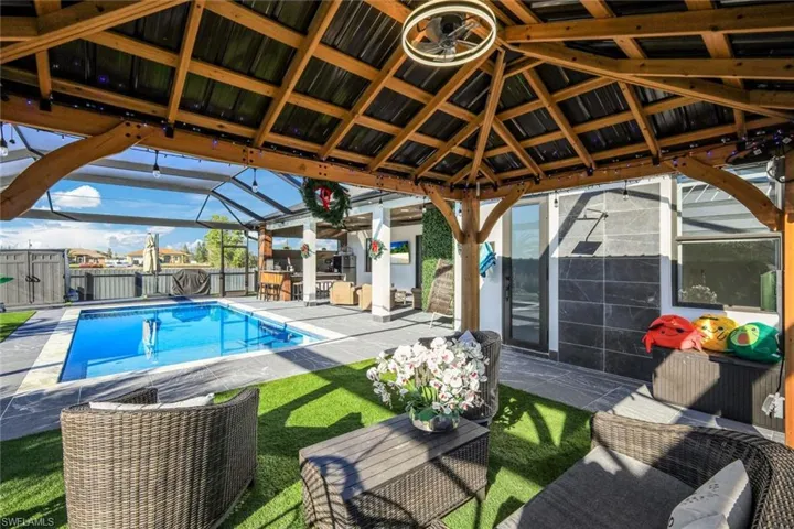 View of swimming pool featuring a fenced in pool, a patio, glass enclosure, and fence