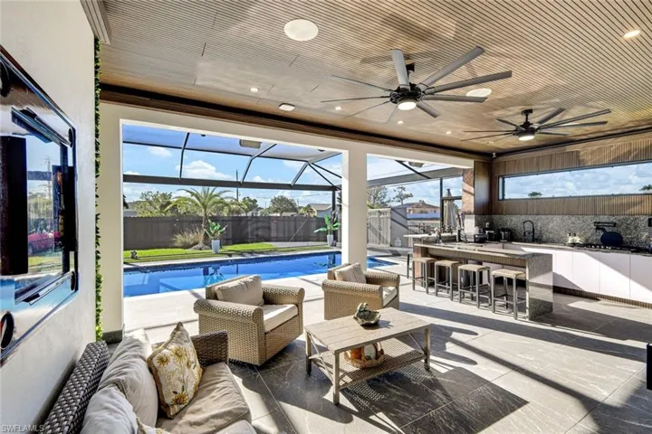 View of patio featuring outdoor dry bar, a fenced in pool, fence, a lanai, and an outdoor hangout area