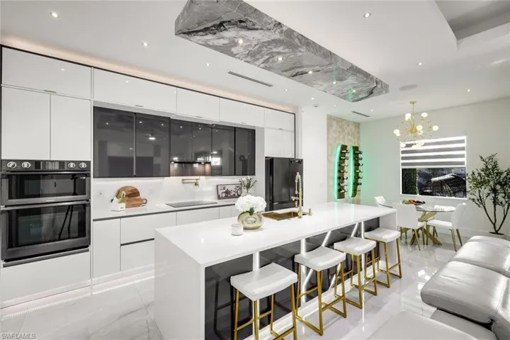 Kitchen with white cabinetry, black appliances, and modern cabinets