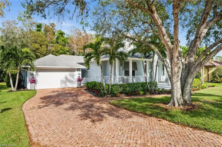Single story home with a front lawn, a porch, and a garage