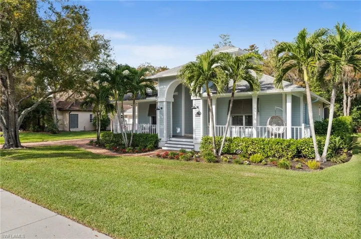 View of front of property with a front yard and covered porch