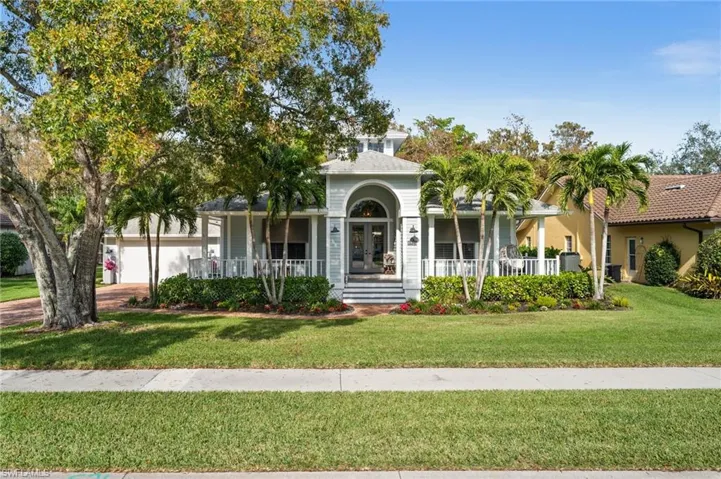 View of front of house with a front yard, french doors, and a garage