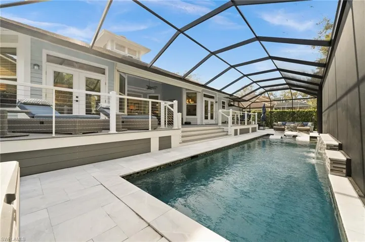 View of swimming pool featuring a lanai, ceiling fan, french doors, and a patio