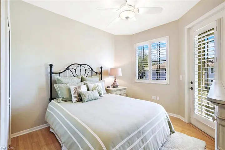 Bedroom with access to outside, light wood-style flooring, and a ceiling fan