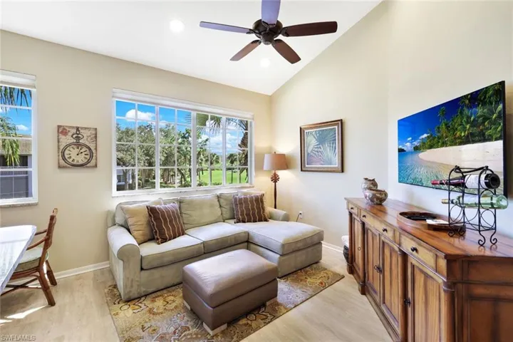 Living area featuring light wood-style flooring, vaulted ceiling, ceiling fan, and recessed lighting
