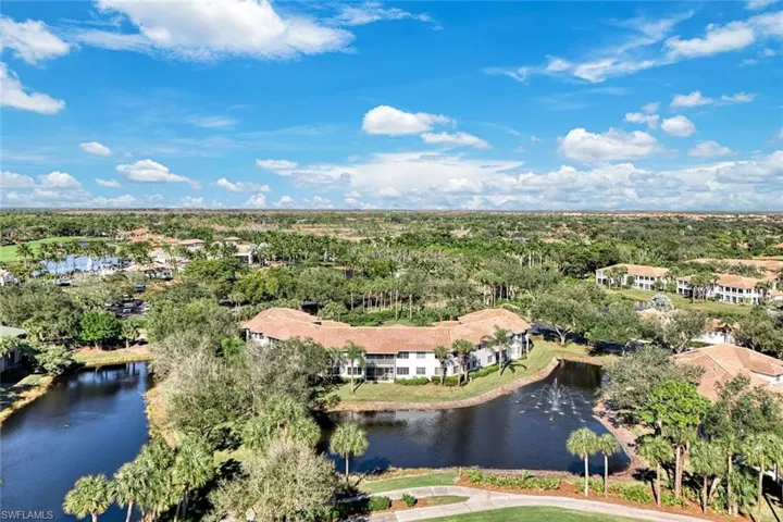 Drone / aerial view of a nearby body of water and a tree filled landscape