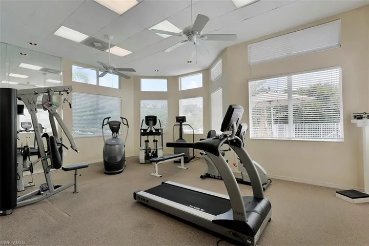 Workout area featuring a high drop ceiling and ceiling fan