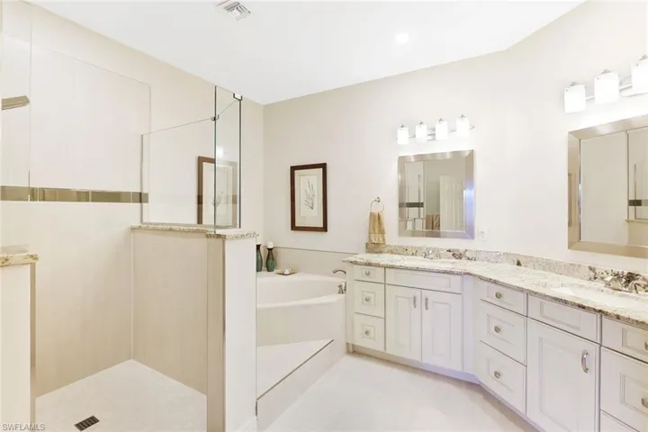 Master Full bathroom featuring double vanity, a garden tub, and a walk in shower