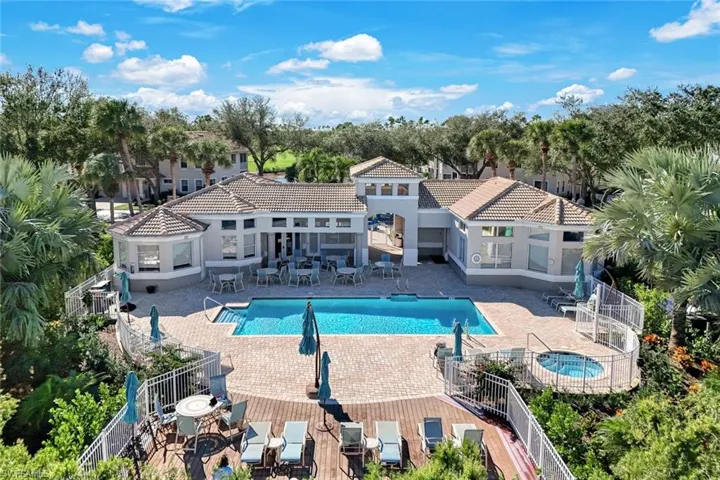 Community pool with a patio, a hot tub, and outdoor dining area
