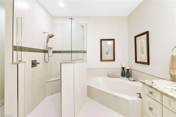 Full bath featuring a garden tub, a walk in shower, and vanity