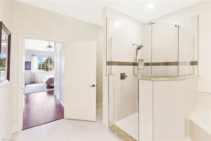 Ensuite bathroom featuring walk in shower, a bath, and ceiling fan