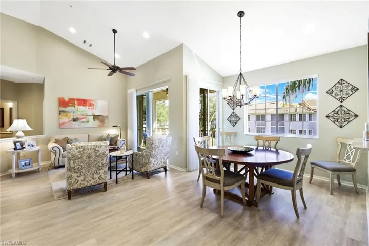 Dining space with vaulted ceiling, light wood-style floors, ceiling fan, and hanging lights