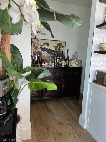Bar featuring light wood-type flooring and open shelves