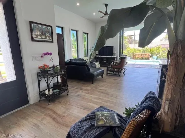 Living room featuring wood finished floors, healthy amount of natural light, a ceiling fan, recessed lighting, and a sunroom