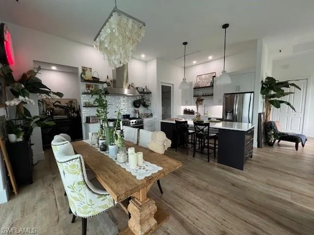 Dining space featuring light wood finished floors, recessed lighting, and a chandelier