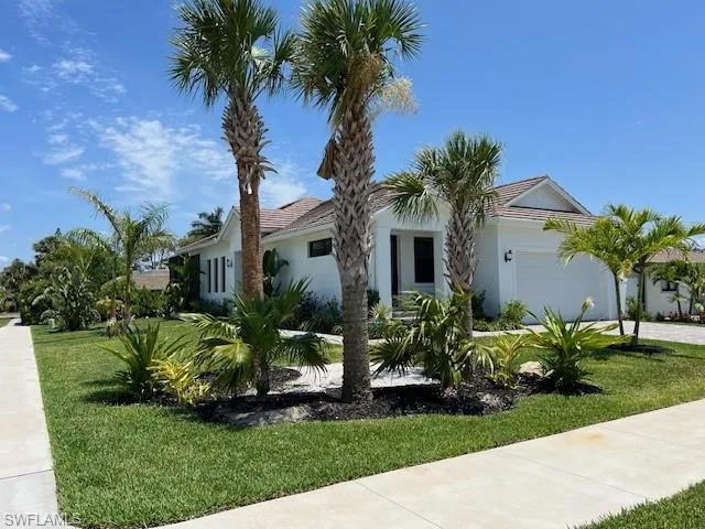 Single story home with a front lawn, stucco siding, and an attached garage