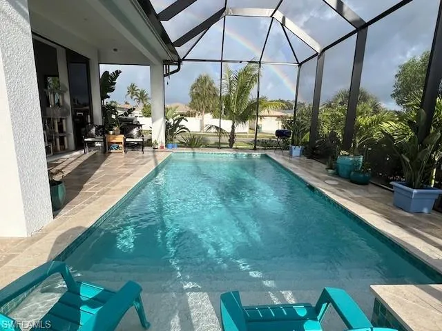 Swimming pool with a patio, a lanai, and a sunroom