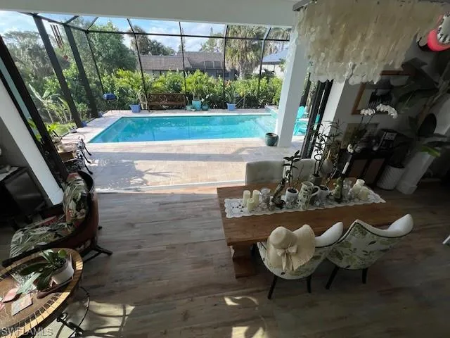 Outdoor pool with a sunroom, a patio, and a lanai