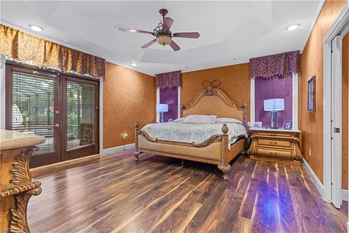Wood-finish flooring with tray ceiling and recessed lighting