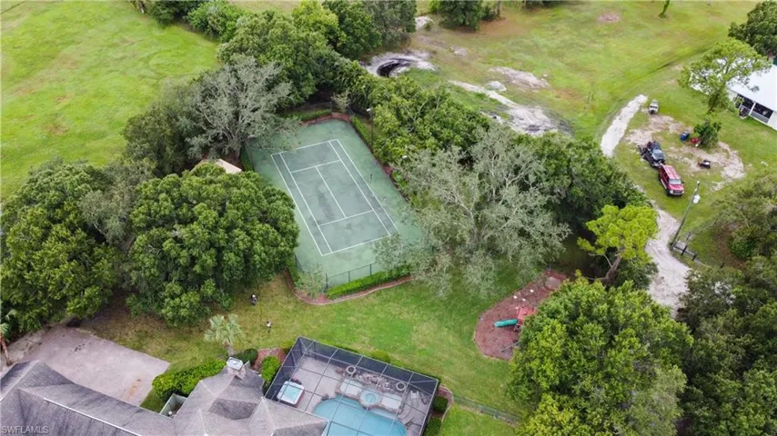 Private tennis court surrounded by mature trees