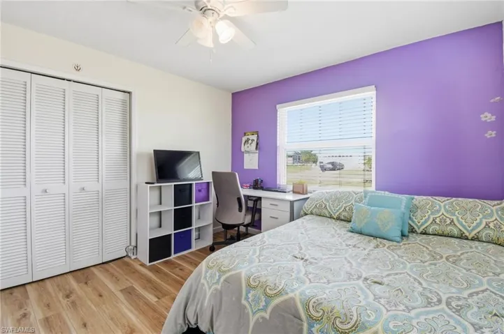 Bedroom featuring light wood finished floors, a closet, and a ceiling fan
