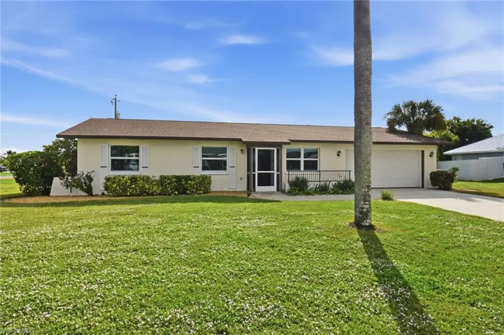 Single story home with stucco siding, driveway, a front lawn, and a garage