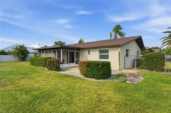 Back of property with stucco siding and a sunroom