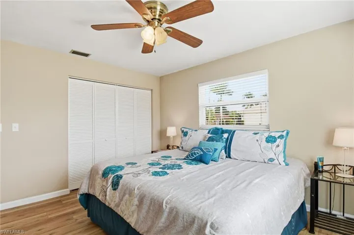 Bedroom with light wood-style flooring, a closet, and ceiling fan