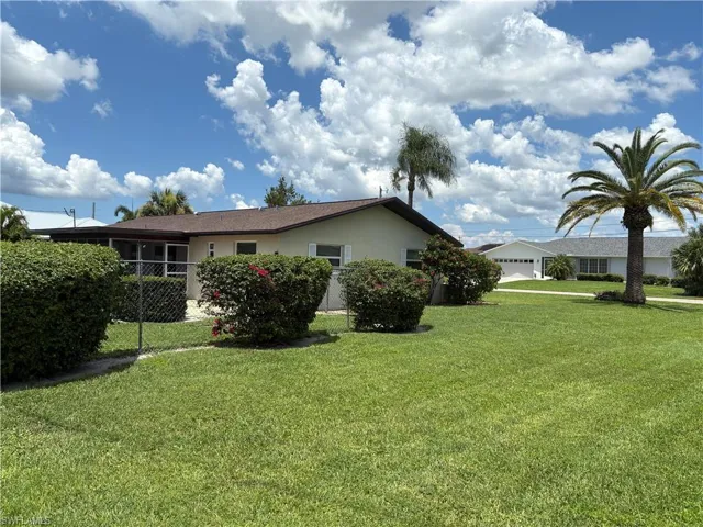 View of side of property featuring stucco siding and a yard
