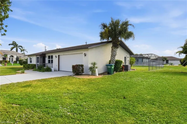 View of property exterior featuring stucco siding, driveway, a yard, and a garage