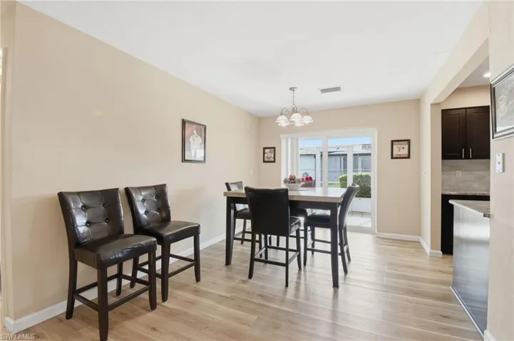 Dining space with light wood finished floors and a chandelier