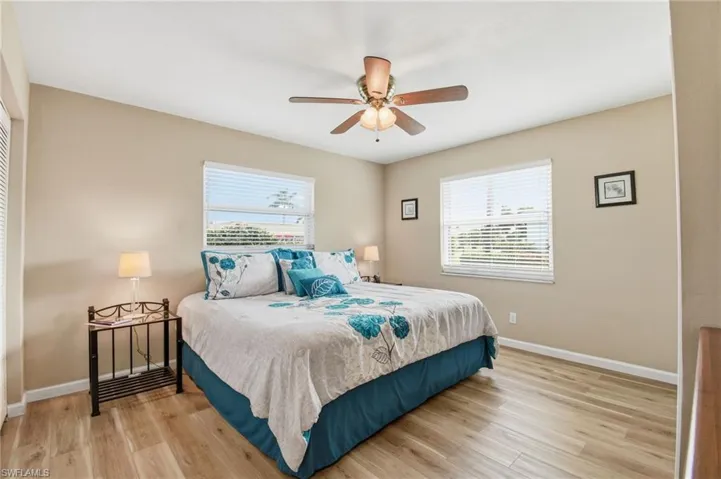 Bedroom featuring light wood-type flooring, multiple windows, and ceiling fan