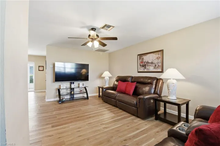 Living area with light wood-type flooring and a ceiling fan