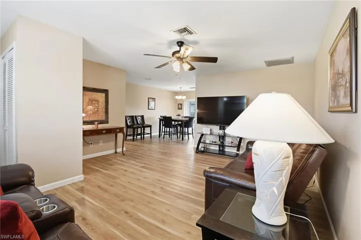 Living area with light wood-style floors and ceiling fan